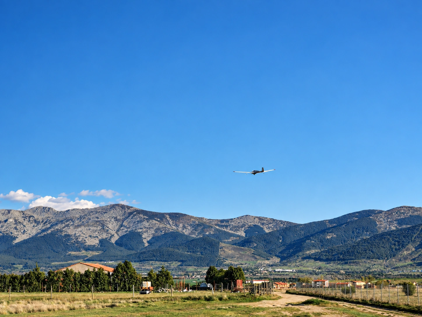 Avioneta sobrevolando el aeródromo de Fuentemilanos con la Sierra de Guadarrama al fondo