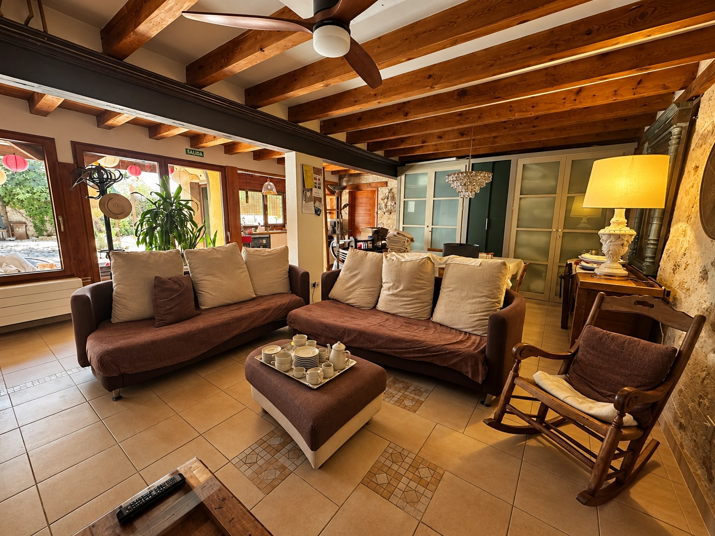 Salón acristalado con sofás y vistas al jardín en la casa rural Viento de Ladera