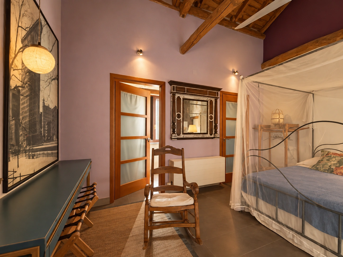Suite con cama con dosel, escritorio y silla de madera en la casa rural